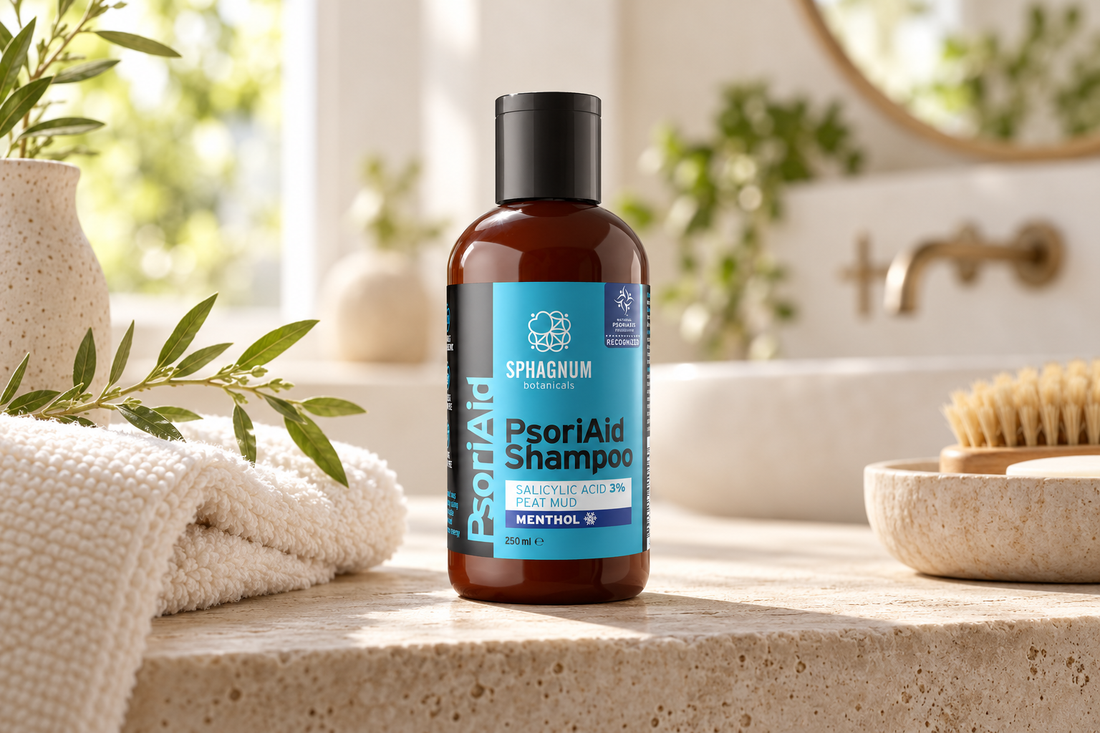 PsoriAid Shampoo with 3% salicylic acid, peat and menthol on a limestone bathroom shelf beside a towel and greenery